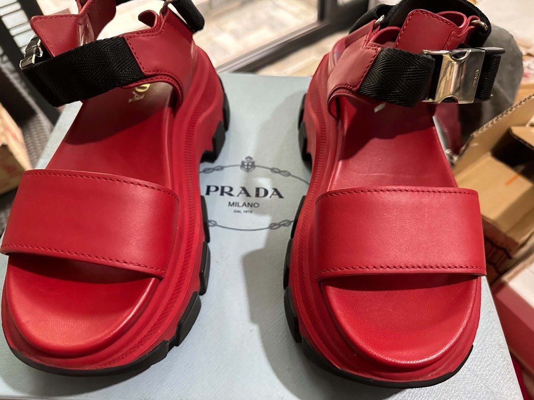 Prada Red Platform Sandals (Category: Flats & Sandals) located in Manila. Submitted by thriftnipapi7 (Listing ID 1464039841, Image 2). Description: - Authentic Red Prada Platform Sandals - Features a chunky sole with black accents - Adjustable straps with secure buckle closure - Exceptionally comfortable and stylish - Versatile for dressing up or down - Original box included.