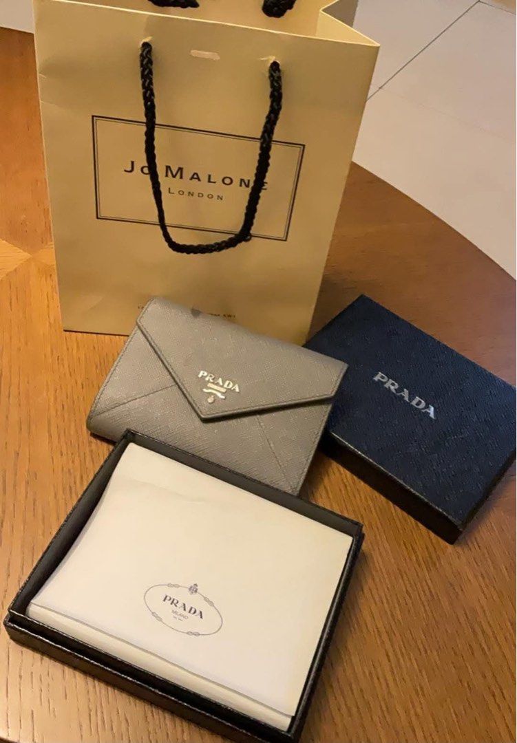 Prada Saffiano Leather Wallet Grey (Category: Wallets & Card holders) located in Manila. Submitted by karlvincen05232 (Listing ID 1464092879, Image 1). Description: - Authentic Prada Wallet - Color: Grey - Material: Saffiano Leather - Style: Envelope with Snap Closure - Features: Multiple Card Slots, Zipped Coin Pocket - Includes: Original Box and Dust Bag.