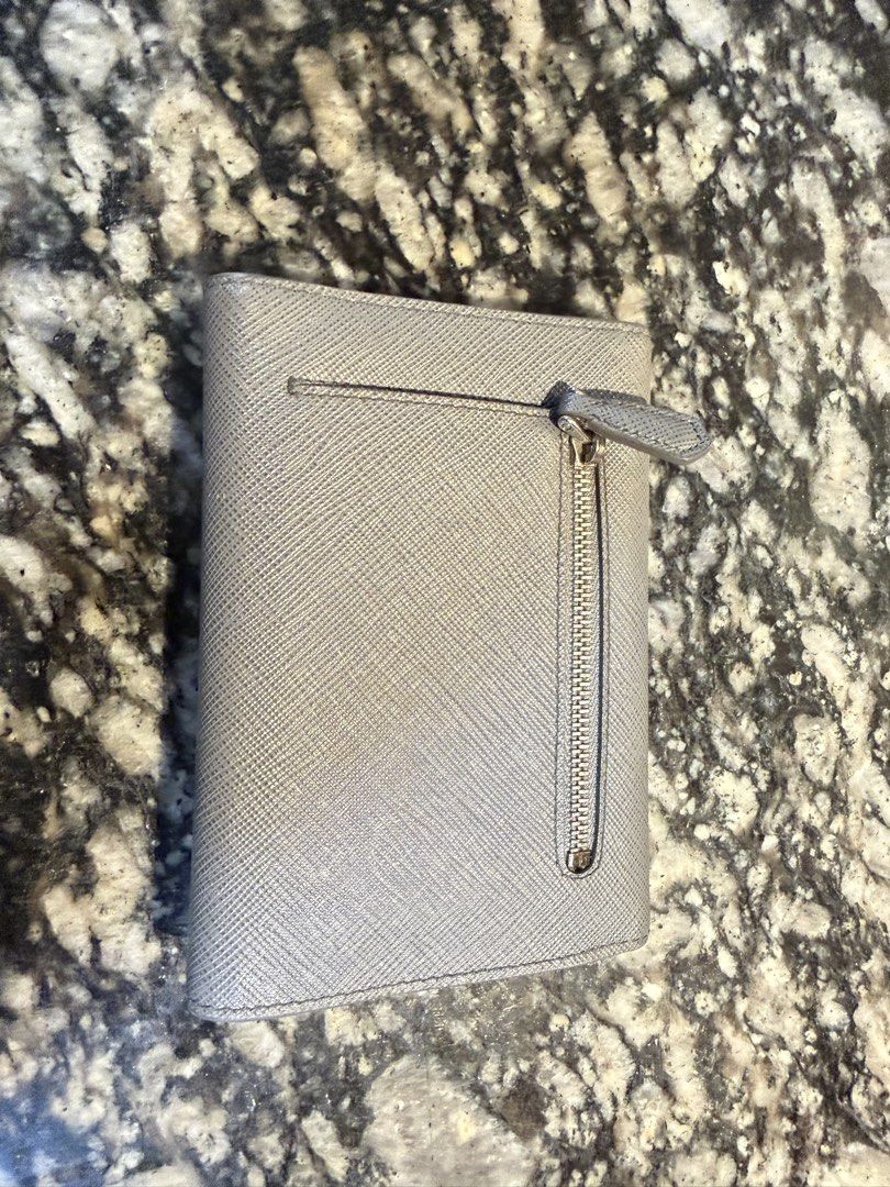 Prada Saffiano Leather Wallet Grey (Category: Wallets & Card holders) located in Manila. Submitted by karlvincen05232 (Listing ID 1464092879, Image 3). Description: - Authentic Prada Wallet - Color: Grey - Material: Saffiano Leather - Style: Envelope with Snap Closure - Features: Multiple Card Slots, Zipped Coin Pocket - Includes: Original Box and Dust Bag.
