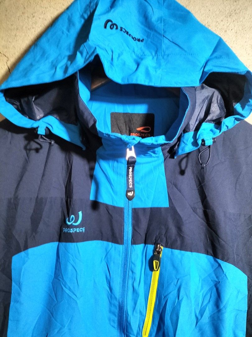 PROSPECS Blue & Navy Hooded Outdoor Jacket (Category: Coats, Jackets and Outerwear) located in Valencia. Submitted by cabisaythriftshop (Listing ID 1464022198, Image 3). Description: - PROSPECS hooded jacket in blue and navy. - Ideal for outdoor activities, hiking, or casual wear. - Features a full zip front closure. - Adjustable hood for customizable coverage. - Equipped with multiple pockets for convenient storage. Prospecs Water Resistance Xla