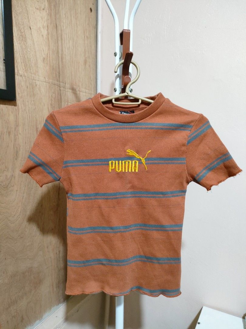 Puma Striped Cropped T-shirt (Category: Shirts) located in Quezon City. Submitted by syayayay (Listing ID 1464064756, Image 1). Description: - Brand: Puma - Style: Cropped T-shirt - Color: Orange and Grey Stripes - Features: Short sleeves, lettuce hem, ribbed material.