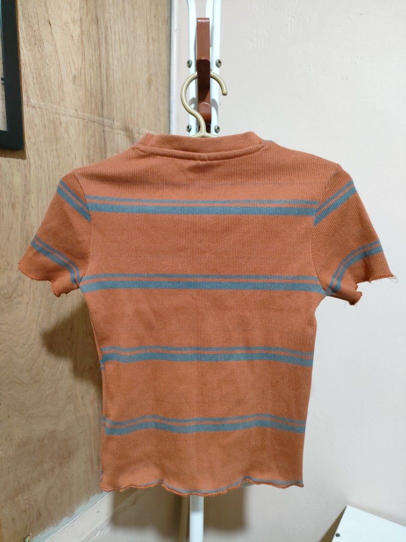 Puma Striped Cropped T-shirt (Category: Shirts) located in Quezon City. Submitted by syayayay (Listing ID 1464064756, Image 2). Description: - Brand: Puma - Style: Cropped T-shirt - Color: Orange and Grey Stripes - Features: Short sleeves, lettuce hem, ribbed material.