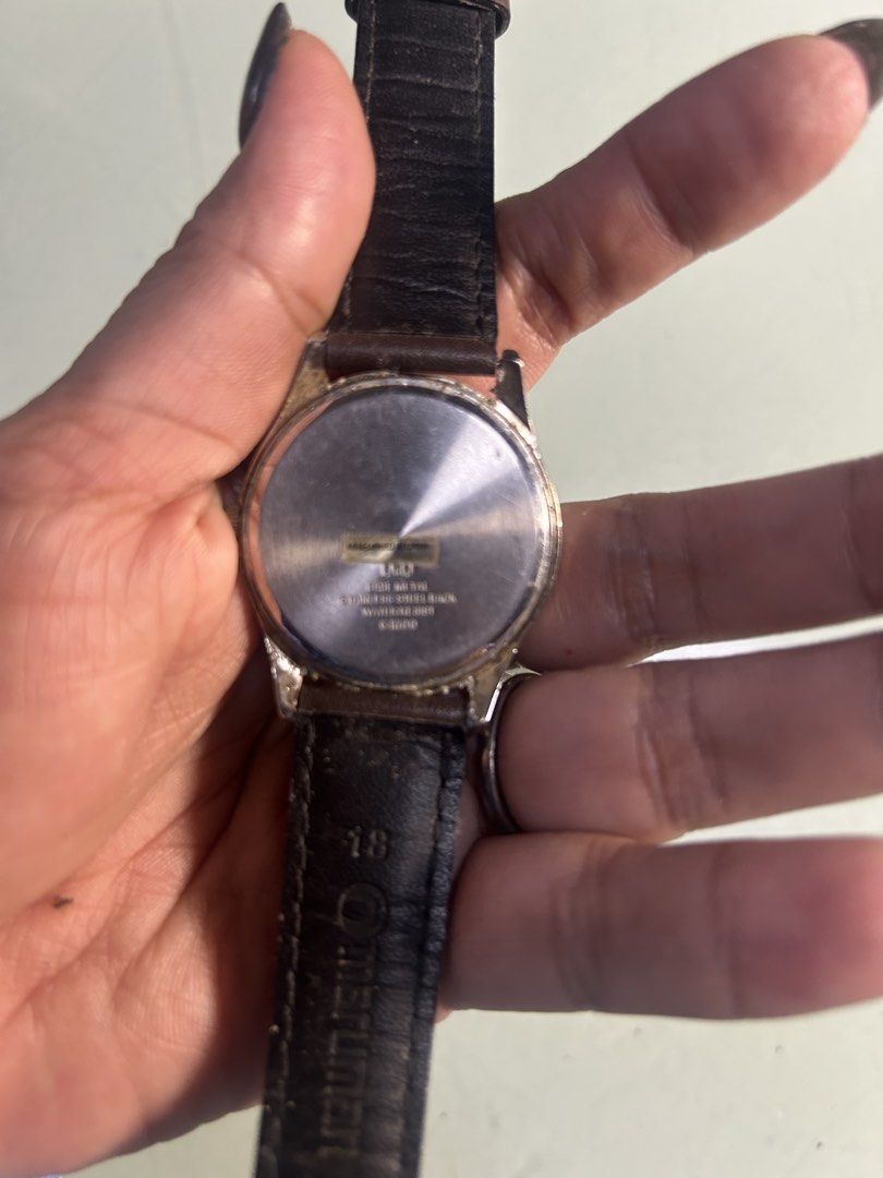Q&Q Quartz Watch with Leather Strap (Category: Men's Watches) located in Cavite. Submitted by mamamia73 (Listing ID 1464036996, Image 3). Description: - Gold-tone analog watch - Displays day and date - Water resistant - Brown leather strap (shows some wear) - Works well - Ideal for everyday wear.