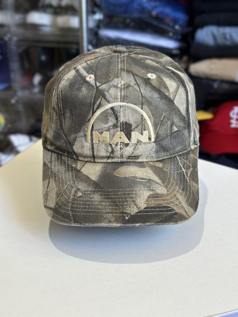 Realtree Camo Cap with MAN Logo (Category: Caps & Hats) located in Daet. Submitted by thrifthings2018 (Listing ID 1463954610, Image 2). Description: - Classic Realtree camouflage baseball cap - Features embroidered 'MAN' logo on the front - Adjustable strap at the back for a comfortable fit - Perfect for outdoor activities or casual wear.
