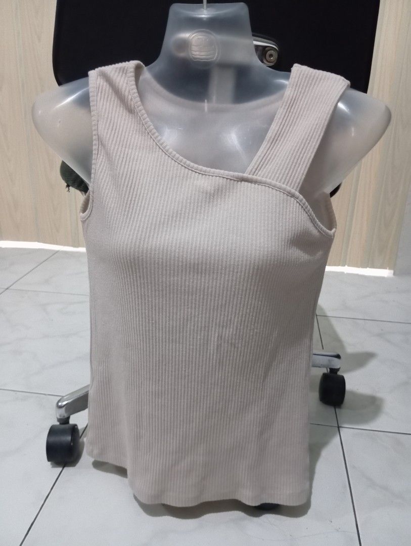 Ribbed Tank Top (Category: Sleeveless) located in Dasmarinas. Submitted by kei05 (Listing ID 1463954866, Image 1). Description: - Cream colored ribbed tank top - Sleeveless with unique chest strap detail - Stretchy and comfortable material - Versatile for layering or wearing on its own - Pairs well with jeans or shorts.