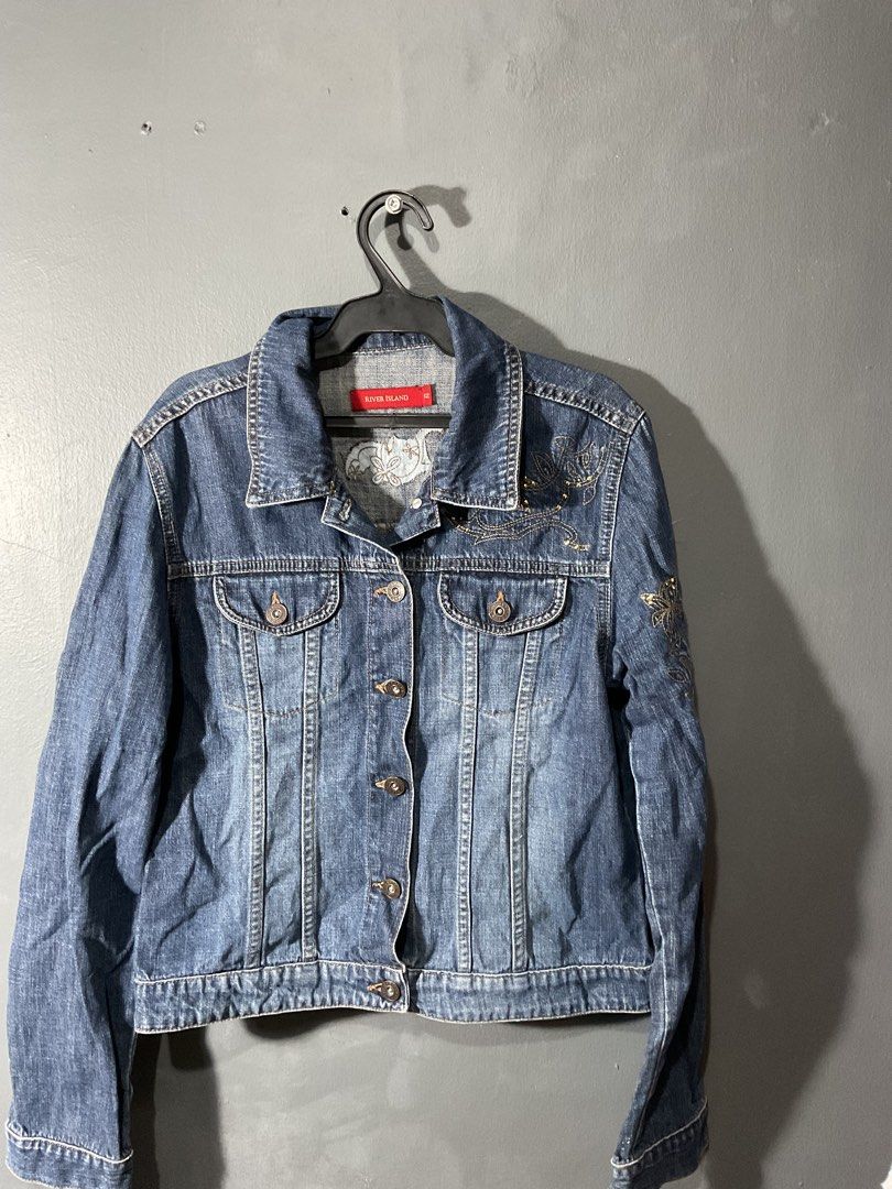 River Island Blue Denim Jacket (Category: Coats, Jackets and Outerwear) located in Manila. Submitted by noblewater-1a3b (Listing ID 1464022919, Image 1). Description: - Classic blue denim jacket from River Island - Features intricate gold embroidery on chest and back - Button-up front with two chest pockets - Versatile for layering over any outfit - Stylish addition to any wardrobe.