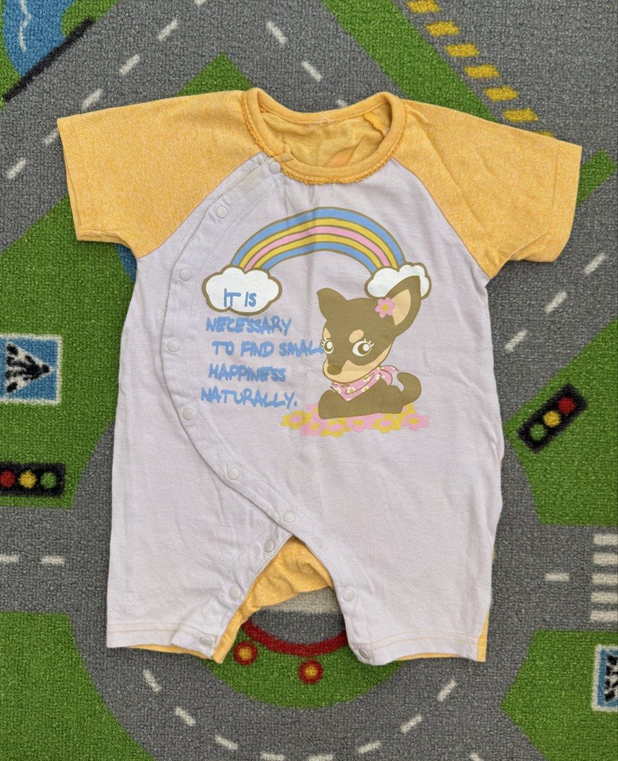 Romper Onesie (Category: Babies & Kids Fashion) located in Rizal. Submitted by preloovved (Listing ID 1463946288, Image 1). Description: - Preloved, 6mos - Adorable baby romper with short sleeves. - Features a cute rainbow and dog graphic. - "It is necessary to find small happiness naturally." text detail. - Convenient snap closures for easy diaper changes and dressing. - Bright yellow sleeves and trim. - Made from soft, comfortable fabric for yo