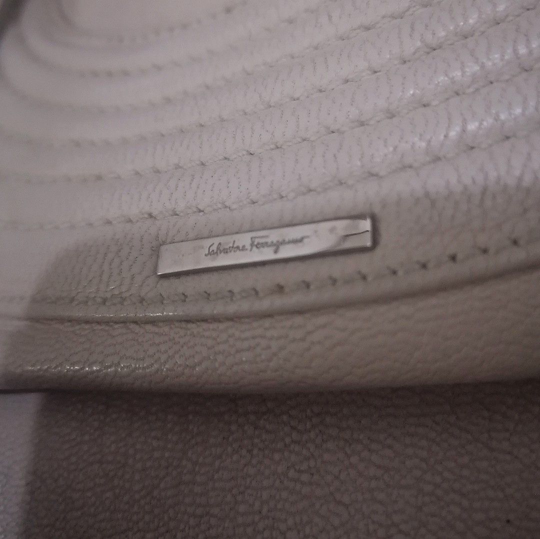 Salvatore Ferragamo Leather Handbag (Category: Luxury Bags & Wallets) located in Cebu City. Submitted by roadthrift (Listing ID 1464041557, Image 3). Description: - Authentic Salvatore Ferragamo leather handbag - Elegant light beige color - Chic gathered detail on the sides - Polished silver hardware with signature brand detailing on zipper pull and front plaque - Functional interior with multiple compartments for organization - Ideal as a stylis