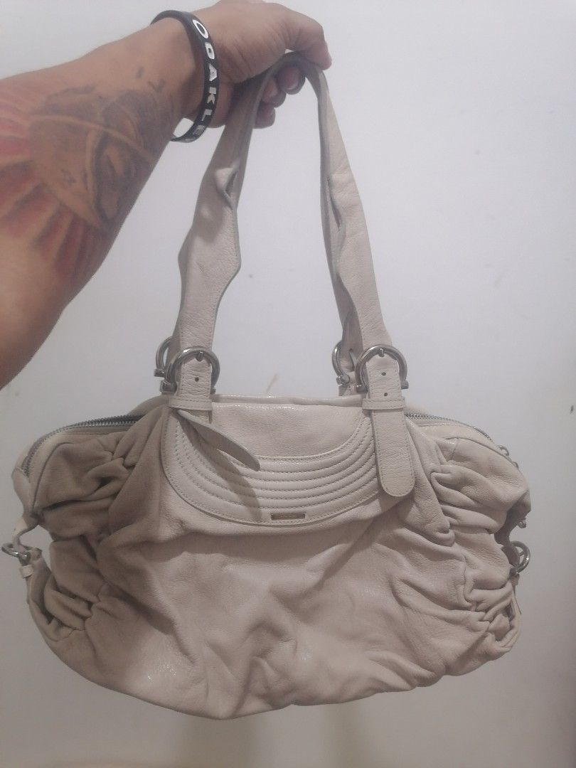Salvatore Ferragamo Leather Handbag (Category: Luxury Bags & Wallets) located in Cebu City. Submitted by roadthrift (Listing ID 1464041557, Image 1). Description: - Authentic Salvatore Ferragamo leather handbag - Elegant light beige color - Chic gathered detail on the sides - Polished silver hardware with signature brand detailing on zipper pull and front plaque - Functional interior with multiple compartments for organization - Ideal as a stylis