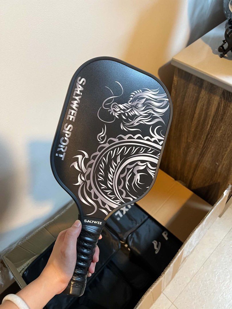 Salywee Pickleball Paddle (Category: Racket and Ball Sports) located in Paranaque City. Submitted by francesann29 (Listing ID 1463976677, Image 1). Description: BRAND NEW SALYWEE Dragon Print Pickleball Paddle Budget-friendly recreational pickleball paddles suited for beginners and casual players This paddle uses an integrated composite carbon fiber material. It is lightweight, shockproof, and reduces arm fatigue. It works well for beginners and 