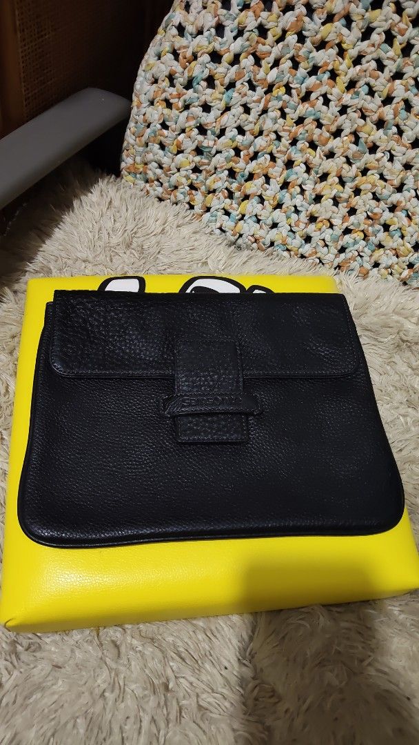 Samsonite Black Leather Clutch Bag with Yellow Accent (Category: Clutches) located in Cebu City. Submitted by lumaynojes00490 (Listing ID 1463971025, Image 3). Description: - Black pebbled leather clutch - Strap closure with subtle embossed logo - Bright yellow accent on the back - Ideal for evenings out or as a statement piece - Clean interior - No major signs of wear.