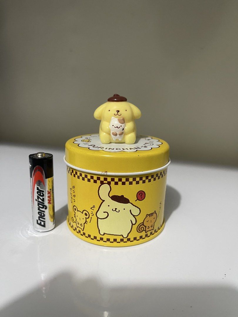Sanrio Pompompurin Tin Can with Figurine (Category: Vintage Collectibles) located in Manila. Submitted by dstrangerthings (Listing ID 1464064321, Image 1). Description: - Adorable Pompompurin tin can with a matching figurine on the lid. - Features charming Pompompurin and friends graphics all around. - Ideal for storing small treasures or as a delightful collectible. - Authentically made in Japan. - Compact size: approximately 3 inches tall..