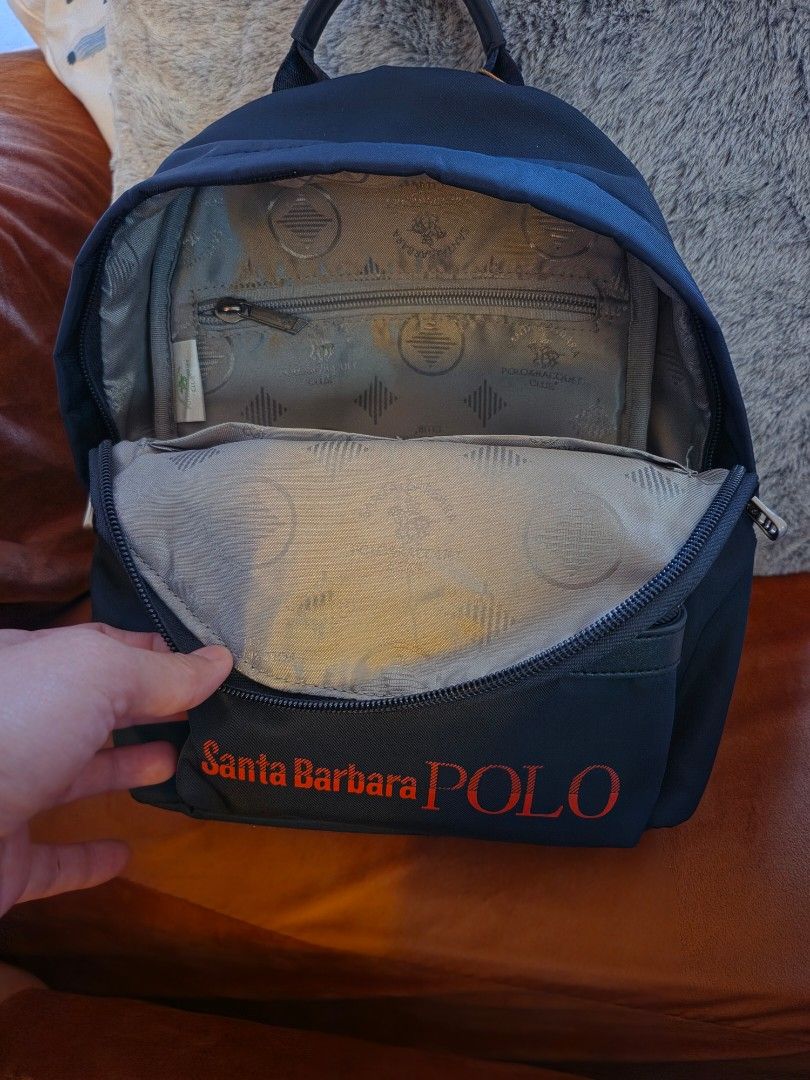 Santa Barbara Polo backpack (Category: Backpacks) located in Manila. Submitted by mybabyprelovedstuff (Listing ID 1463974644, Image 3). Description: - Brand: Santa Barbara Polo & Racquet Club - Color: Black with red logo - Features: Front zip pocket, main compartment, inner zip pocket - Straps: Adjustable - Ideal for: Everyday use, travel small bag.