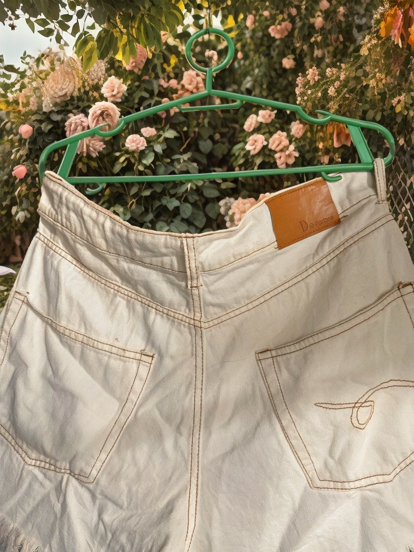 SHORT: a white denim short Large size on tag button fly. (Category: Shorts) located in Calumpit. Submitted by painkiller2526 (Listing ID 1463980974, Image 3). Description: These are white denim shorts featuring an asymmetric cross-over waistband and distressed frayed hems. Message me to those who are interested MOP: Gcash GoTyme MariBank SF: shoulder by the buyer.