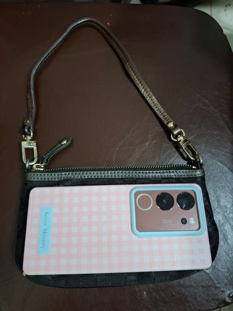Sisley Black Monogram Kili Pouch with Wrist Strap (Category: Purses & Pouches) located in Cavite. Submitted by mahthriftshop (Listing ID 1463983067, Image 2). Description: kili pouch fits iphone and android mop gcash+sf - Stylish black pouch with repeating monogram pattern. - Includes a detachable brown leather wrist strap. - Secure zipper closure for your belongings. - Interior zippered pocket for added organization. - Fits your phone and other 