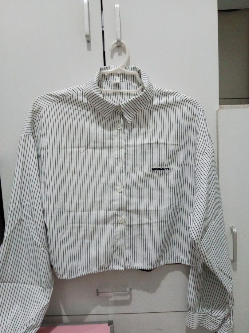 Striped Cropped Button-Up Shirt (Category: Shirts) located in Manila. Submitted by lofiley (Listing ID 1464028492, Image 1). Description: - White shirt with thin black vertical stripes - Cropped length - Long sleeves - Button-up front - Small embroidered detail on chest pocket - Relaxed fit.