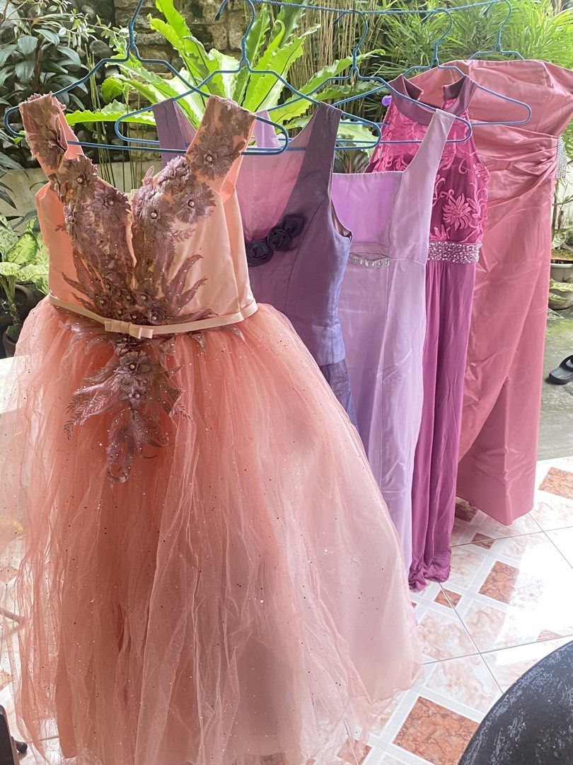 TAKE ALL 7 Assorted Gowns - Pink, Purple, Lavender (Category: Dresses) located in Davao. Submitted by alessuh (Listing ID 1463965646, Image 1). Description: - Stunning collection of formal dresses perfect for any event or party. - Includes a beautiful peach tulle gown with intricate beadwork. - Elegant purple satin gown available. - Lovely lavender and pink dresses adorned with embellishments and floral accents. - All pieces are unique and crafte