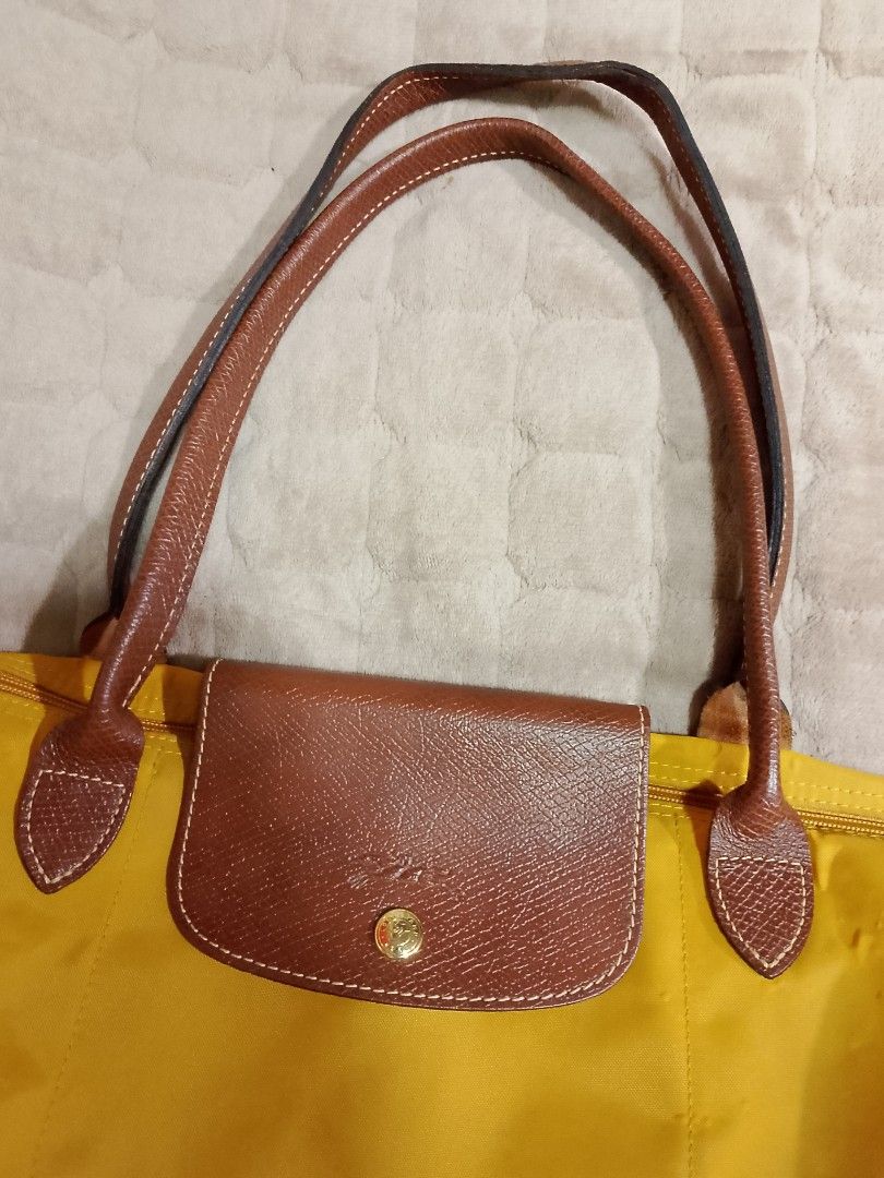 The Longchamp Le Pliage (Category: Tote Bags) located in Caloocan City. Submitted by pvaliao (Listing ID 1464037309, Image 2). Description: Brand: Longchamp Le Pliage shoulder tote bag Color: Yellow Mustard Size: 19 inches × 13 inches Fabric: main body made from a lightweight, durable polyamide canvas or nylon . Trim and handles: Russian Leather textured cowhide Water resistant Preloved Selling price: 1500 Still Negotiable pm for more details Buy