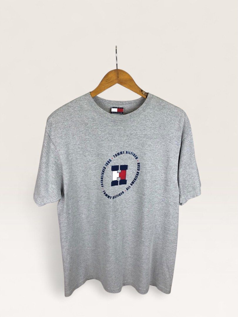 Tommy Hilfiger Grey T-Shirt (Category: Tshirts & Polo Shirts ) located in Manila. Submitted by 12essentials (Listing ID 1464029698, Image 1). Description: 📌 Excellent Condition 📌 S on tag fits M 📌 Length 28’ Width 20.5’ Grey Tommy Hilfiger t-shirt. Features the classic Tommy Hilfiger logo graphic on the front. Established 1985, All American Gear. Made from a cotton-polyester blend. Size S/P..