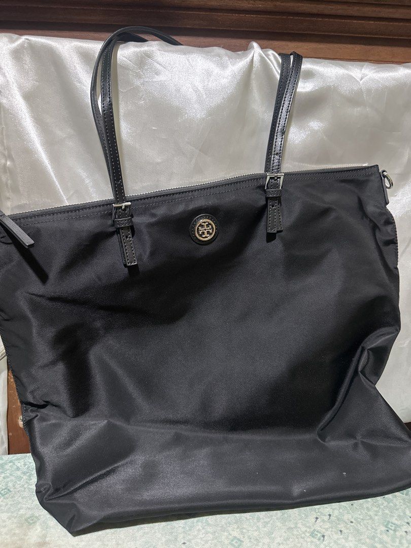 Tory Burch Black Nylon Tote Bag (Category: Tote Bags) located in Balanga. Submitted by jk2025. (Listing ID 1463958030, Image 1). Description: - Authentic Tory Burch tote bag in black. - Made from durable nylon with stylish leather straps. - Secure top zipper closure. - Elegant gold Tory Burch logo accent. - Spacious interior, ideal for everyday essentials or travel. - Versatile and practical for any occasion..