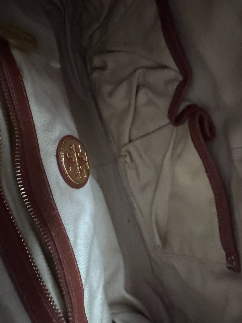 Tory Burch Brown Horsebit Satchel (Category: Luxury Bags & Wallets) located in Makati City. Submitted by mbrtom (Listing ID 1463989665, Image 3). Description: As is. Stained lining from use and storage. Strap not included. Smooth zipper. Thread / stiches coming off from one strap hook. Outside leather in very good condition. No scuffs and navy blue piping intact. Good size for a daily bag. Zipper also provides some safety for personal effects. Au