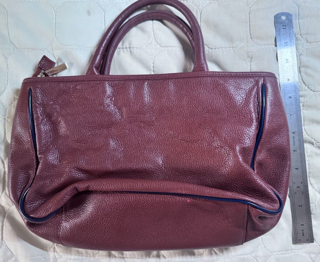 Tory Burch Brown Horsebit Satchel (Category: Luxury Bags & Wallets) located in Makati City. Submitted by mbrtom (Listing ID 1463989665, Image 2). Description: As is. Stained lining from use and storage. Strap not included. Smooth zipper. Thread / stiches coming off from one strap hook. Outside leather in very good condition. No scuffs and navy blue piping intact. Good size for a daily bag. Zipper also provides some safety for personal effects. Au