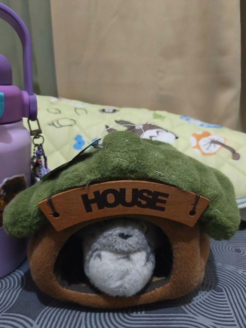 Totoro Plush in a House Bed (Category: Plushies & Soft Toys) located in Cebu City. Submitted by __sen (Listing ID 1463982617, Image 1). Description: - Adorable totoro plush peeking out from its charming little house. - House features a green, mossy roof and a wooden 'HOUSE' sign. - Plush toy is soft and features a grey and white color scheme. - Ideal for home decoration or as a cute collectible item. - Totoro tag is Sun Arrow - Comes with origina