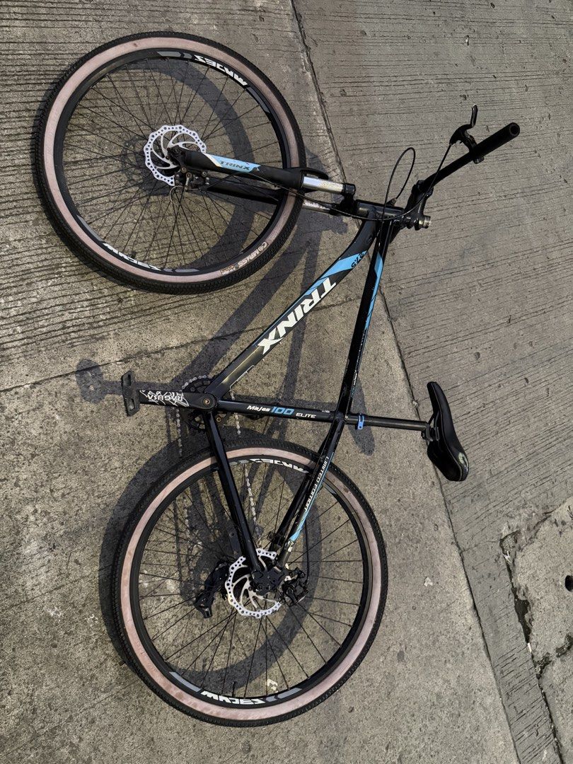 TRINX Majes 100 Elite Mountain Bike (Category: Bicycles) located in Manila. Submitted by muchoc06 (Listing ID 1464036892, Image 1). Description: - TRINX Majes 100 Elite Mountain Bike - Color: Black frame with blue accents - Features: Disc brakes (front & rear), Shimano Tourney derailleur - Tires: Light tan sidewalls - Condition: Ready for trails or city riding.