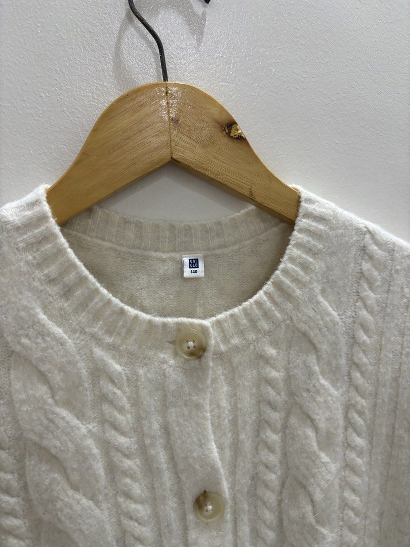 Uniqlo Cable Knit Cardigan (Category: Coats, Jackets and Outerwear) located in Bulacan. Submitted by janeeeeelleeeee (Listing ID 1464121680, Image 2). Description: - Cream cable knit cardigan from Uniqlo - Round neckline with button closure - Long sleeves with ribbed cuffs and hem - Cozy and versatile for layering - Ideal for casual wear - Size 140 on tag, XS to S - mall bought for 1490.