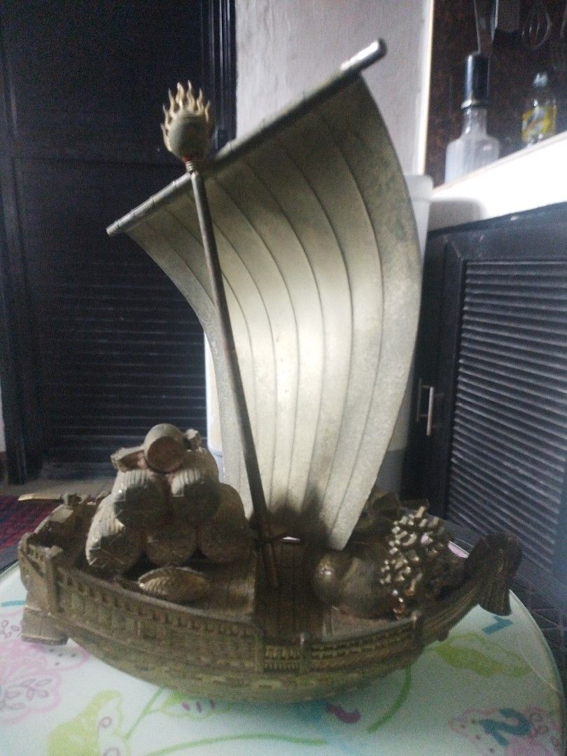 Vintage japanesse treasure ship (Category: Vintage Collectibles) located in San Rafael. Submitted by jflshoppe1989 (Listing ID 1463987735, Image 2). Description: size lenght 9 inches height 10 inches Type: Decorative tabletop sculpture / lucky charm ornamentDesign: Features a traditional sailing ship with an engraved sail depicting a phoenix and pine branches, carrying auspicious cargo like treasure sacks and bales.Material: Appears to be a metal