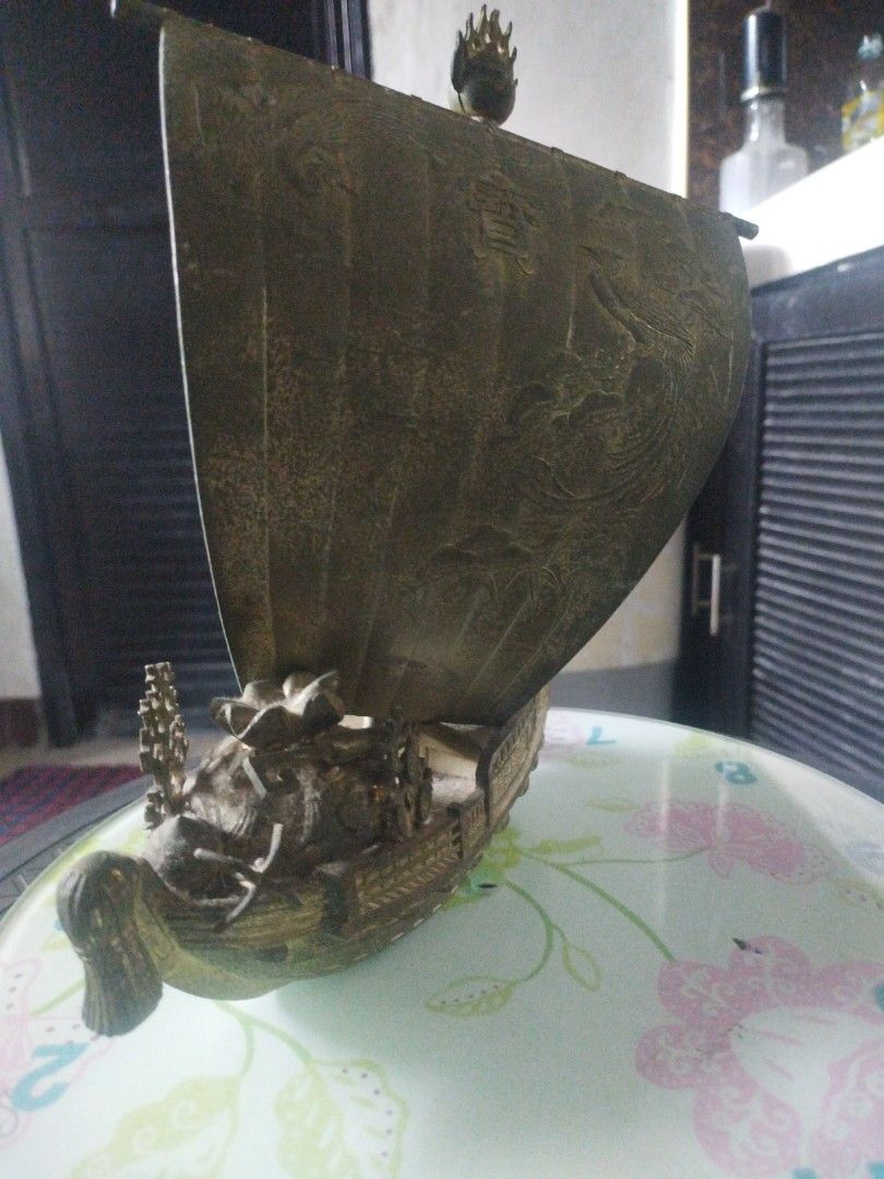 Vintage japanesse treasure ship (Category: Vintage Collectibles) located in San Rafael. Submitted by jflshoppe1989 (Listing ID 1463987735, Image 3). Description: size lenght 9 inches height 10 inches Type: Decorative tabletop sculpture / lucky charm ornamentDesign: Features a traditional sailing ship with an engraved sail depicting a phoenix and pine branches, carrying auspicious cargo like treasure sacks and bales.Material: Appears to be a metal