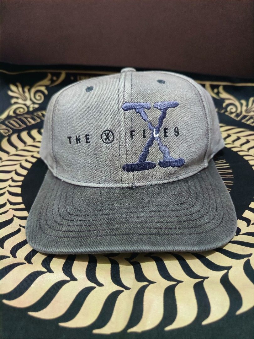Vintage The X-Files Embroidered Baseball Cap (Category: Caps & Hats) located in Jaen. Submitted by ratbunizer (Listing ID 1463900156, Image 2). Description: - Grey and dark green baseball cap - Embroidered 'The X-Files' logo on the front - Adjustable strap for a comfortable fit - Perfect for X-Files fans.