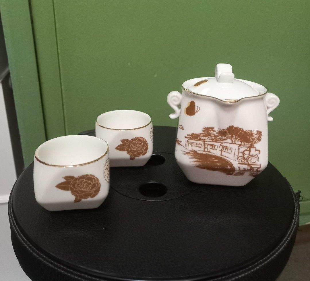 White Ceramic Tea Set with Gold Floral Design (Category: Coffee & Tea Tableware) located in Makati City. Submitted by rnst1 (Listing ID 1463959642, Image 1). Description: - Beautiful white ceramic tea set - Includes teapot with lid and handles, and two cups - Decorated with exquisite gold floral patterns and a landscape scene - Cups feature elegant gold rims - Comes in a ready-to-gift box - Ideal for serving tea or as a stunning decorative piece.