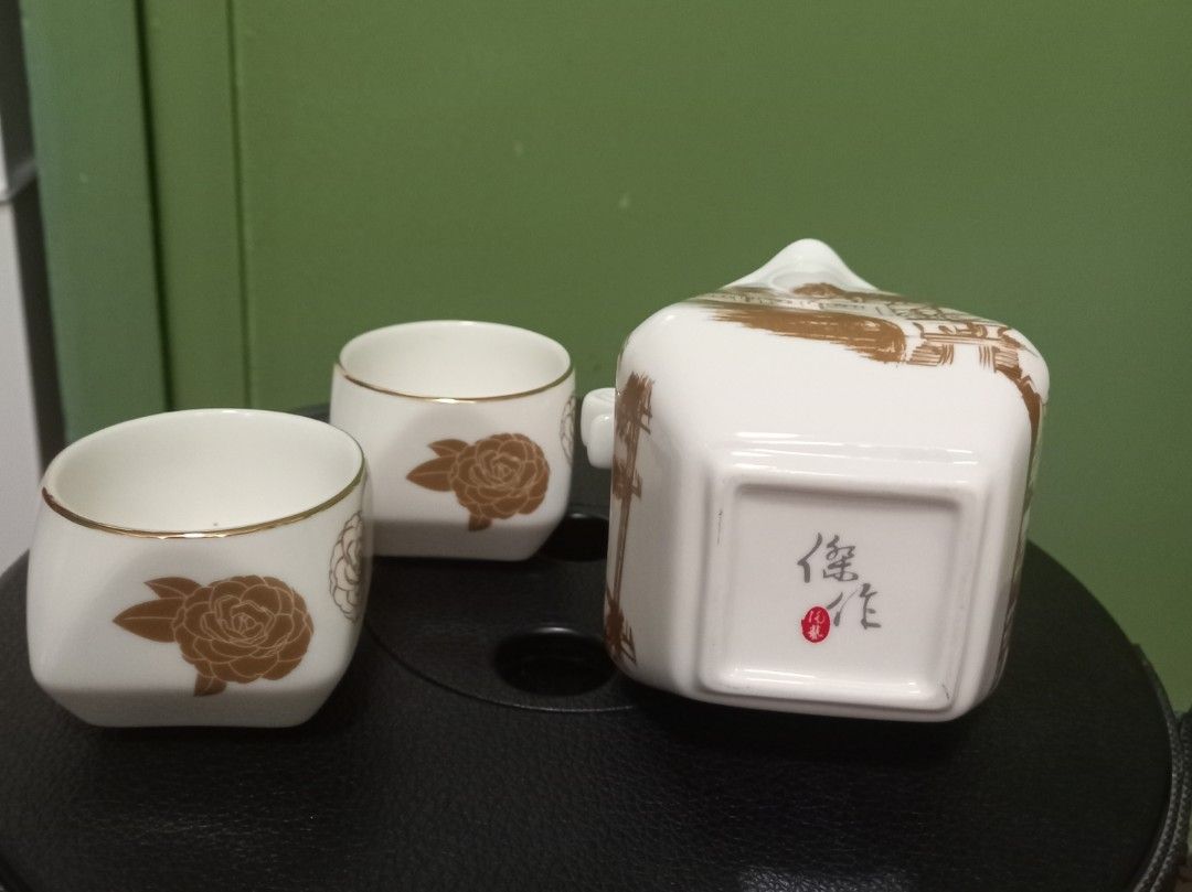 White Ceramic Tea Set with Gold Floral Design (Category: Coffee & Tea Tableware) located in Makati City. Submitted by rnst1 (Listing ID 1463959642, Image 2). Description: - Beautiful white ceramic tea set - Includes teapot with lid and handles, and two cups - Decorated with exquisite gold floral patterns and a landscape scene - Cups feature elegant gold rims - Comes in a ready-to-gift box - Ideal for serving tea or as a stunning decorative piece.