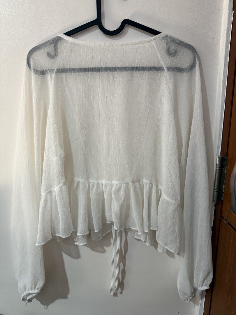 White Sheer Long Sleeve Cover Up (Category: Blouses) located in Quezon City. Submitted by shuartcake (Listing ID 1464023576, Image 2). Description: - White sheer blouse - Long sleeves - Tie front closure - Ruffled hem - Lightweight and flowy material - Ideal for layering over swimwear or camisole - Medium to Large size - Adds a delicate touch to any outfit.