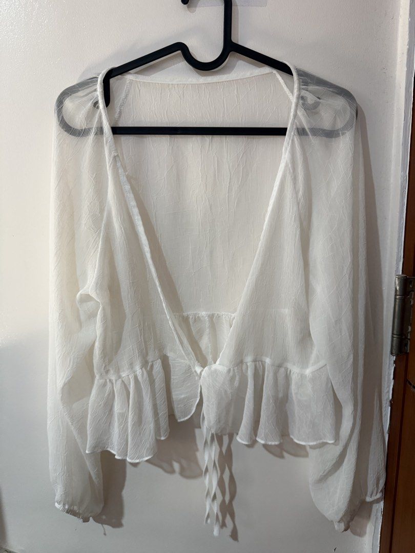 White Sheer Long Sleeve Cover Up (Category: Blouses) located in Quezon City. Submitted by shuartcake (Listing ID 1464023576, Image 1). Description: - White sheer blouse - Long sleeves - Tie front closure - Ruffled hem - Lightweight and flowy material - Ideal for layering over swimwear or camisole - Medium to Large size - Adds a delicate touch to any outfit.