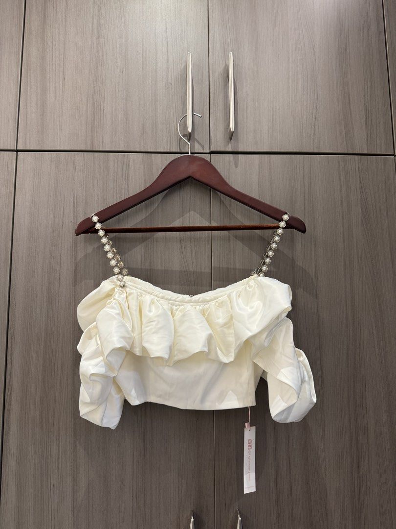 White Silk Pearl Straps with Off-Shoulder Ruffle Set (Category: Sleeveless) located in Quezon City. Submitted by declutteringmycloset__ (Listing ID 1463950595, Image 1). Description: - White off-shoulder crop top - Ruffled bust detail - High waisted matching skirt - Elegant pearl strap accents - Ideal for night outs or special occasions.