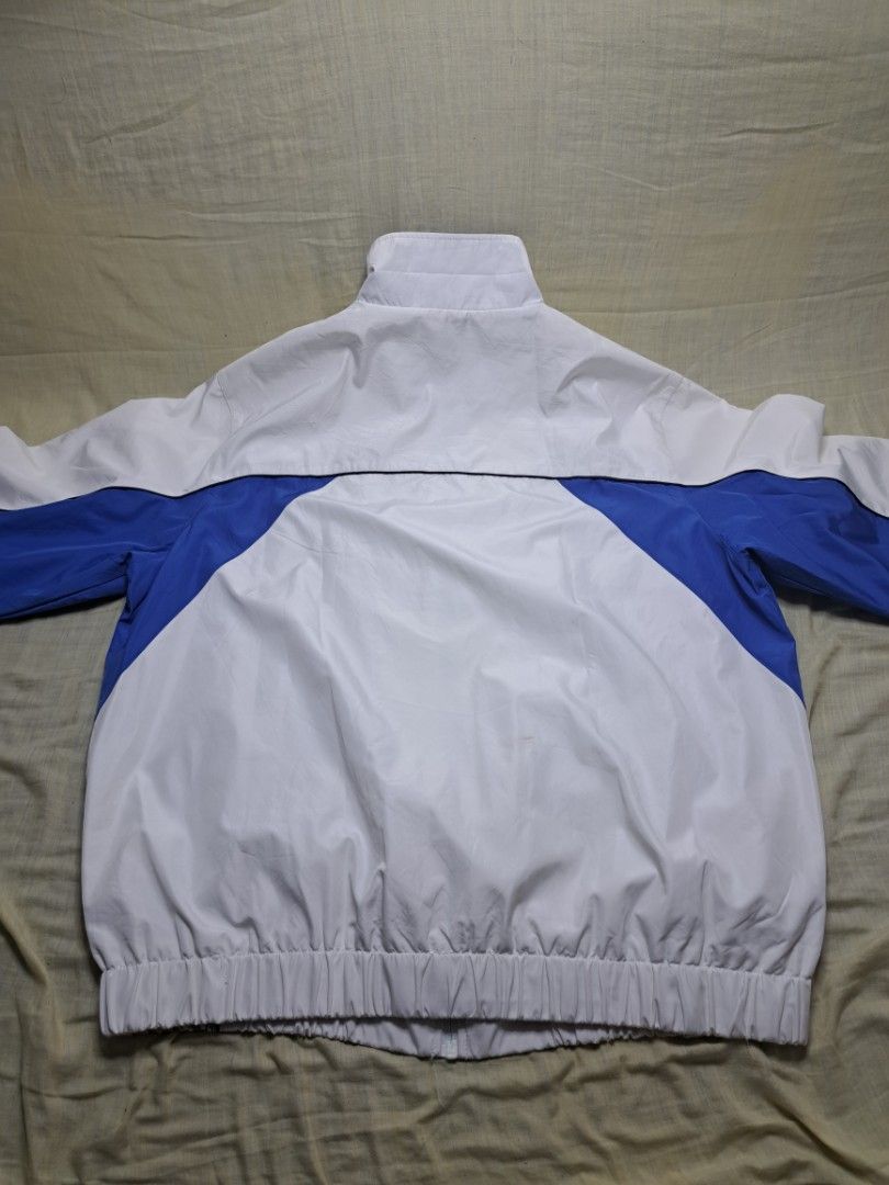 Windbreaker (Category: Coats, Jackets and Outerwear) located in Manila. Submitted by sainty.exe (Listing ID 1463991841, Image 3). Description: - White track jacket with blue sleeve and side accents - Subtle star graphic on left chest and sleeve - Full zip front closure - Elasticated cuffs and hem for a snug fit - Size L to XL - Two front pockets for convenience - Inner mesh lining for breathability.