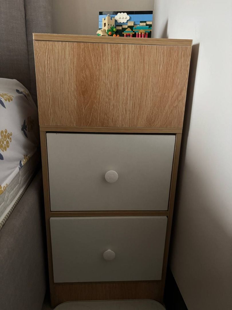 Wooden Nightstand with 2 White Drawers (Category: Shelves, Cabinets & Racks) located in Makati City. Submitted by swiftwind_fd3653 (Listing ID 1463979968, Image 1). Description: - Stylish nightstand with a light wood grain top - Features two clean white drawers with round white knobs - Ideal for storing bedside essentials like books, remotes, or glasses - Compact design fits perfectly next to any bed - Selling because of a home redecoration.