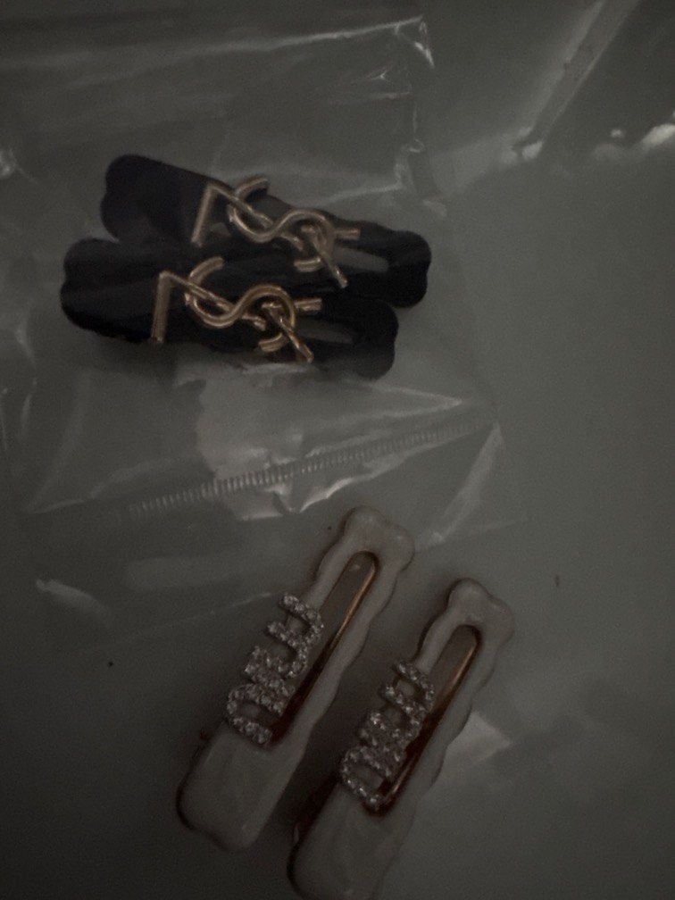 YSL & Rhinestone Hair Clips Set (Category: Hair Accessories) located in Manila. Submitted by decluterthings888 (Listing ID 1464030846, Image 1). Description: - Set of 2 chic hair clips - One clip features a gold YSL logo on black - Second clip is white with rose gold accents and 'DREAM' spelled out in rhinestones - Adds a touch of glamour and flair to any hairstyle.