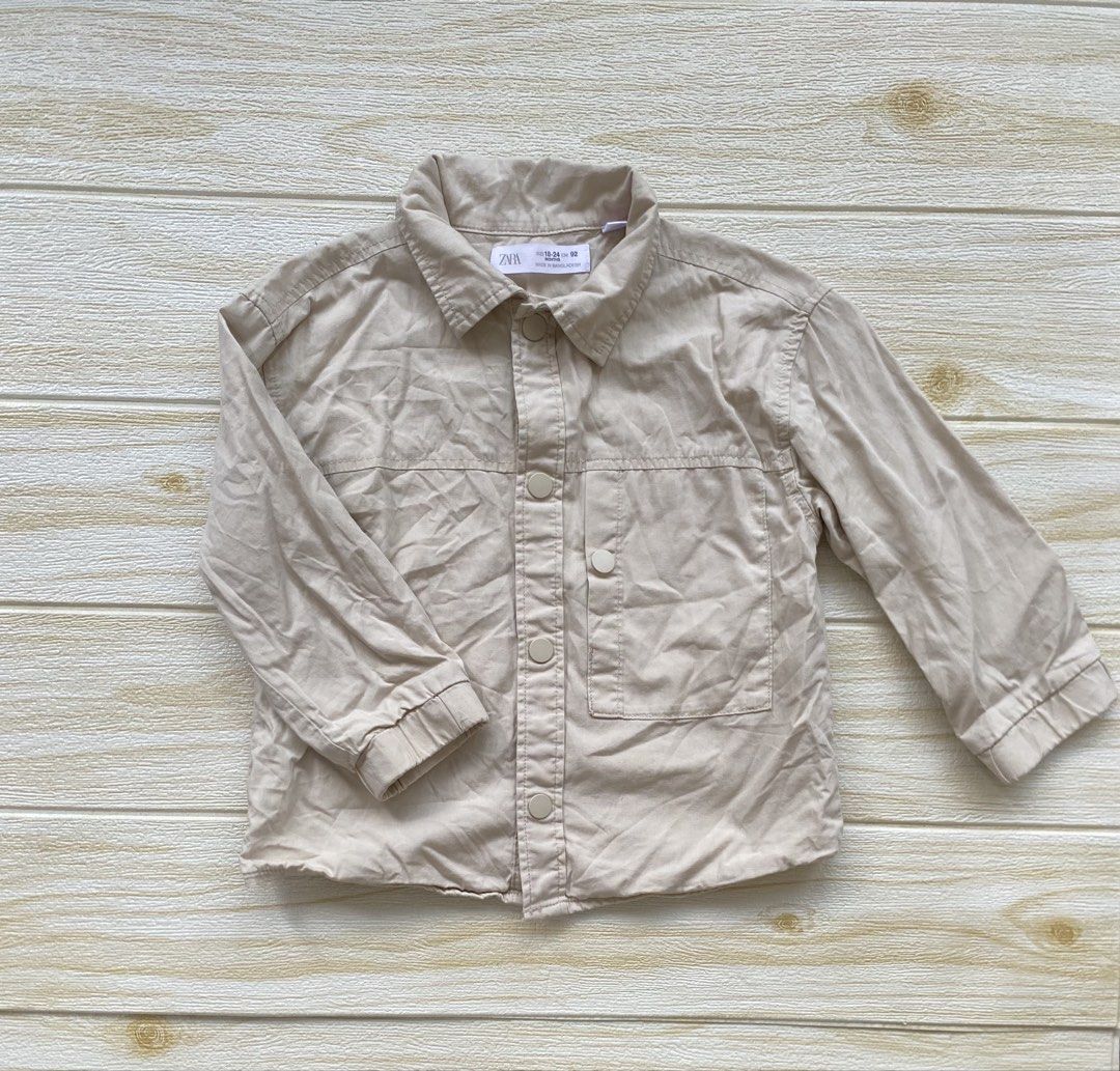 Zara cream cargo-style overshirt (Category: Babies & Kids Fashion) located in Cebu City. Submitted by yjainani (Listing ID 1463966327, Image 1). Description: light beige Zara cotton overshirt featuring a "Sunset Waves" graphic with fish printed on the back.