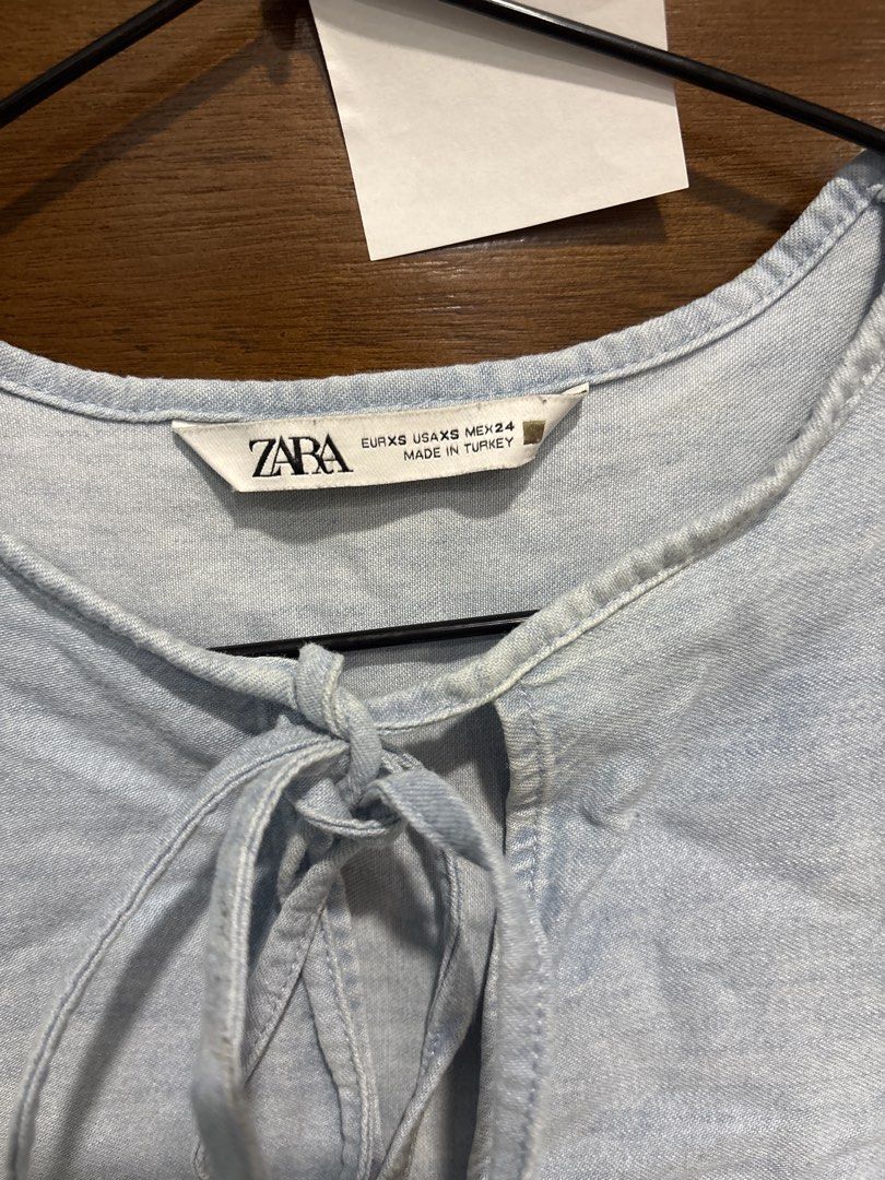 ZARA Light Blue Tiered Denim-look Top (Category: Sleeveless) located in Mandaluyong City. Submitted by clothescarousel (Listing ID 1464055330, Image 2). Description: - Light blue Zara top - Resembles denim but is a lighter fabric - Features a stylish tie-neck detail - Tiered and flowy design for a relaxed silhouette - Three-quarter sleeves with a subtle puff - Ideal for casual wear.