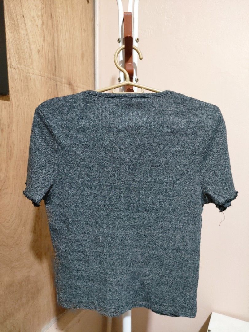 Zara Ribbed Button-Up Cropped Top (Category: Sleeveless) located in Quezon City. Submitted by syayayay (Listing ID 1464064295, Image 2). Description: - Zara grey ribbed cropped top - Short sleeves with lettuce hem detail - Button-up front - Ideal for casual wear or layering.