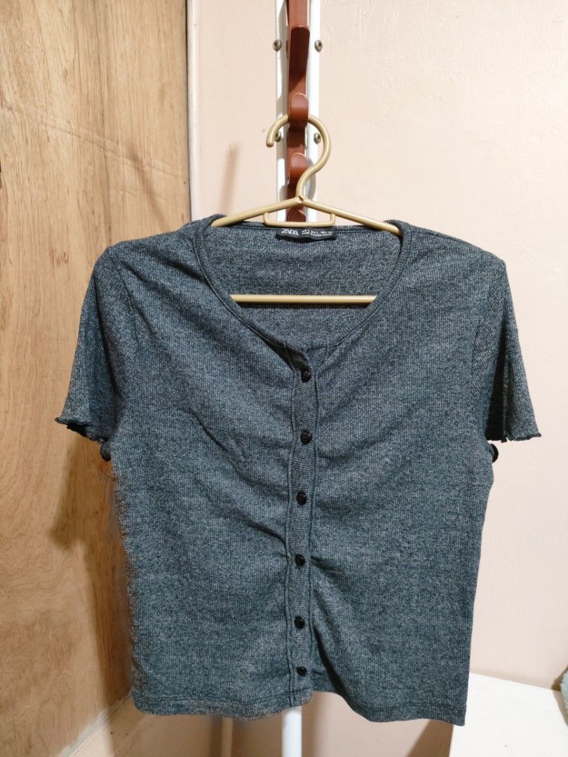 Zara Ribbed Button-Up Cropped Top (Category: Sleeveless) located in Quezon City. Submitted by syayayay (Listing ID 1464064295, Image 1). Description: - Zara grey ribbed cropped top - Short sleeves with lettuce hem detail - Button-up front - Ideal for casual wear or layering.