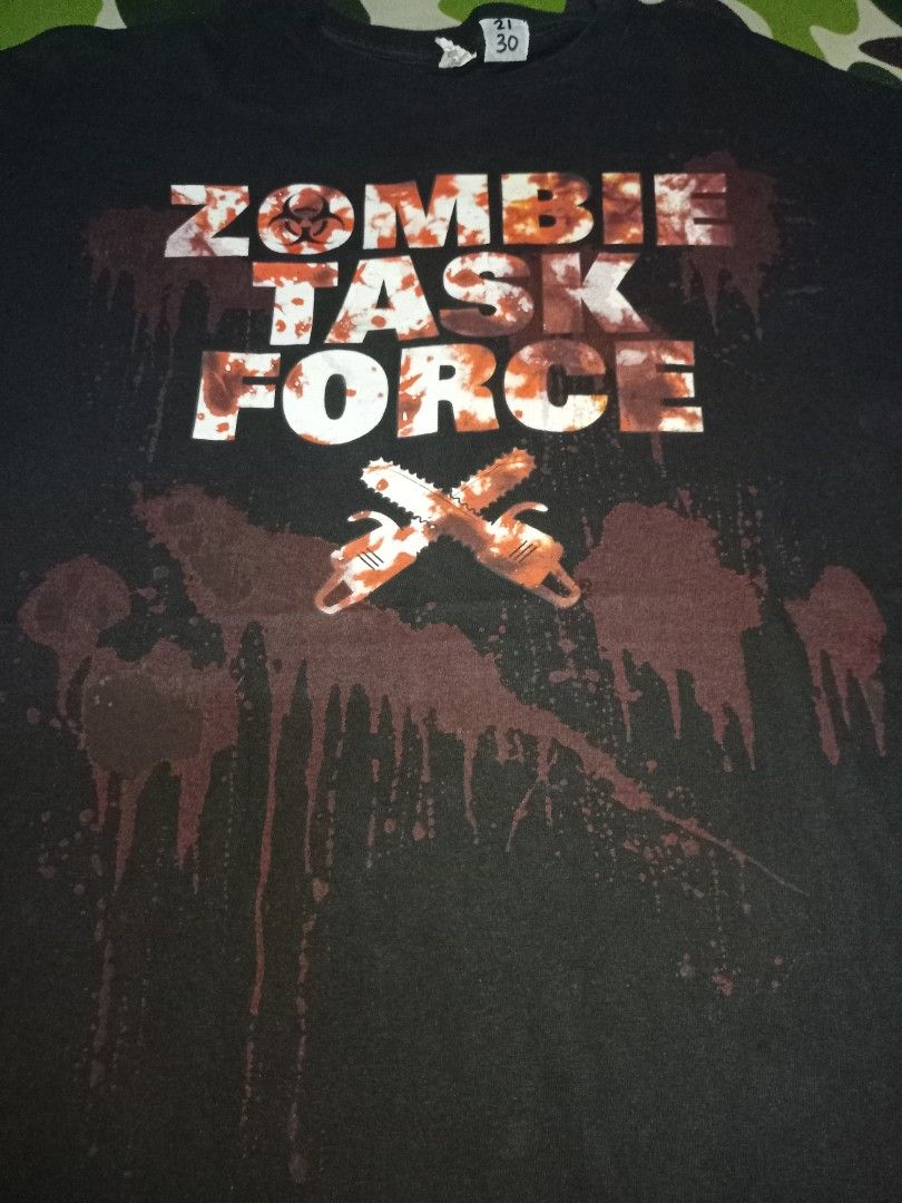 Zombie Task Force (Category: Tshirts & Polo Shirts) located in Kuala Terengganu. Submitted by babyshambles_strokes (Listing ID 1463942346, Image 1). Description: - Black t-shirt with 'Zombie Task Force' graphic - Features blood splatter and chainsaw design - Made from Data Pro Weight material - Tag size: 21 /30 - Ideal for horror and zombie enthusiasts.