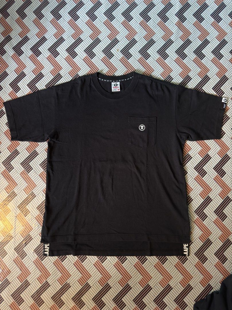 AAPE BY A BATHING APE Black Pocket Tee (Category: Tshirts & Polo Shirts ) located in Cagayan de Oro. Submitted by thrifteecdo (Listing ID 1464201713, Image 2). Description: - Black Aape T-shirt (Long back design) - 9/10 color rate. Excellent condition - Dimes ; Width- 22 inches Front length- 26 inches Back length- 28 inches - Chest pocket with Aape logo - Aape logo repeated on sleeve cuff - Aape branding along bottom hem - 100% Cotton - Tagged Si