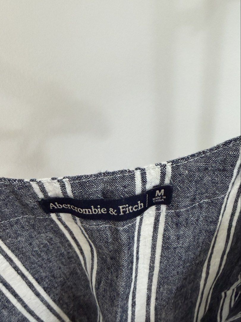 Abercrombie & Fitch Striped Button-Front Cami Top Size M (Category: Sleeveless) located in Cebu City. Submitted by jnnwright (Listing ID 1464168373, Image 2). Description: - Navy and white striped cami top - Brand: Abercrombie & Fitch - V-neckline with button details - Adjustable spaghetti straps - Material: Linen blend fabric - Versatile: Great for layering or wearing on its own.