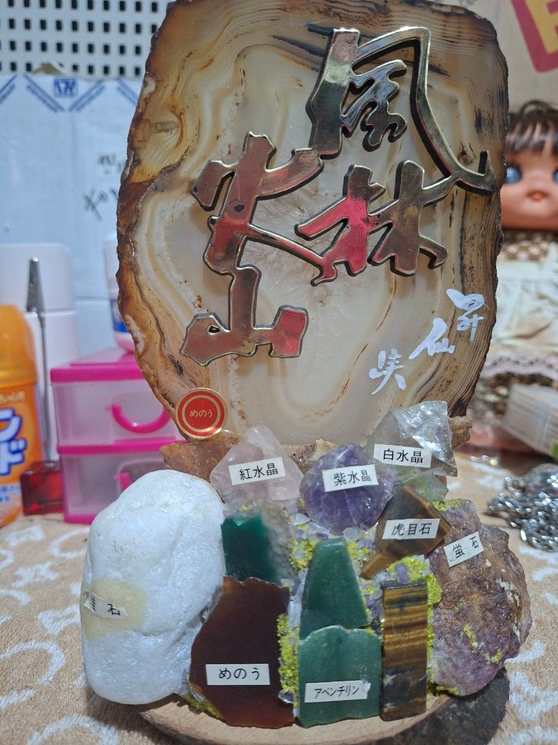 Agate Slice Display with Assorted Gemstones and Japanese Calligraphy (Category: Precious Stones) located in Lucena. Submitted by dai_suki (Listing ID 1464341192, Image 2). Description: - Unique agate slice with a sturdy wooden base. - Features an elegant decorative metal calligraphy piece. - Includes a collection of small, polished gemstones: amethyst, tiger's eye, and aventurine. - Some labels are in Japanese, adding an exotic touch. - Ideal for