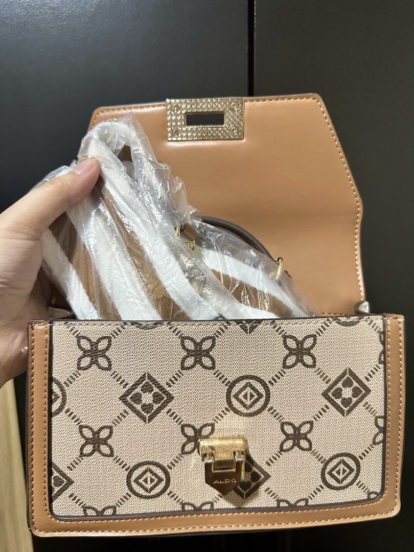 ALDO Monogram Chain Shoulder Bag (Category: Shoulder Bags) located in Manila. Submitted by biskybysh (Listing ID 1464346742, Image 3). Description: - Cute ALDO bag with signature monogram print - Colorway: Tan, white, and brown - Gold chain strap - Clasp closure - Interior still wrapped in plastic - Great for going out.