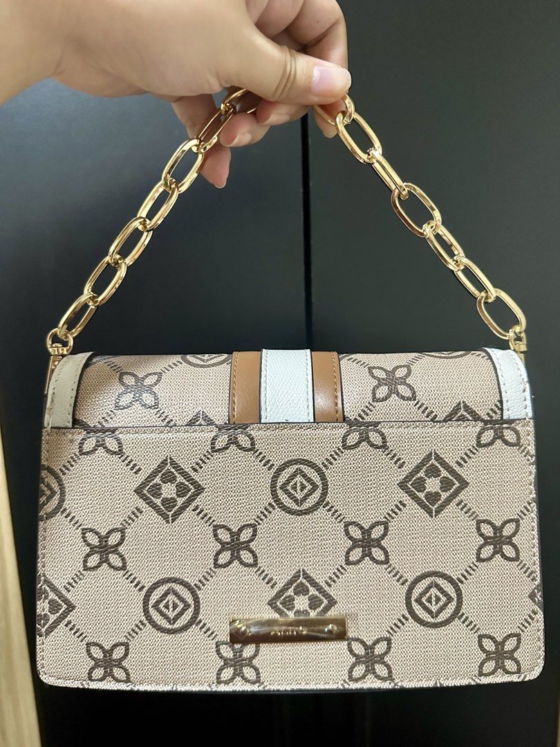 ALDO Monogram Chain Shoulder Bag (Category: Shoulder Bags) located in Manila. Submitted by biskybysh (Listing ID 1464346742, Image 2). Description: - Cute ALDO bag with signature monogram print - Colorway: Tan, white, and brown - Gold chain strap - Clasp closure - Interior still wrapped in plastic - Great for going out.